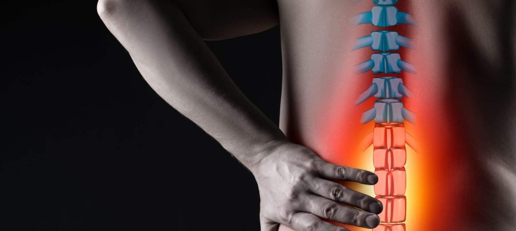 Pain in the spine, man with backache on black background, intervertebral hernia or disc injury concept